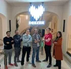 En grupp människor står framför en Deezer-logotyp. De flesta har armarna i kors.