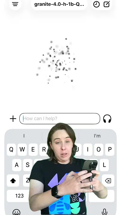 En person håller en mobiltelefon med en AI-chattapp öppen. Ett tangentbord syns på skärmen.