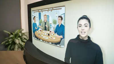 En kvinna framför en skärm som visar tre män vid ett matbord.