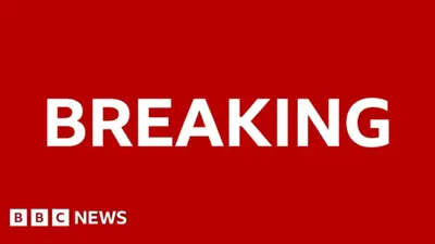 Röd bakgrund med texten "BREAKING" och "BBC NEWS" i vitt.